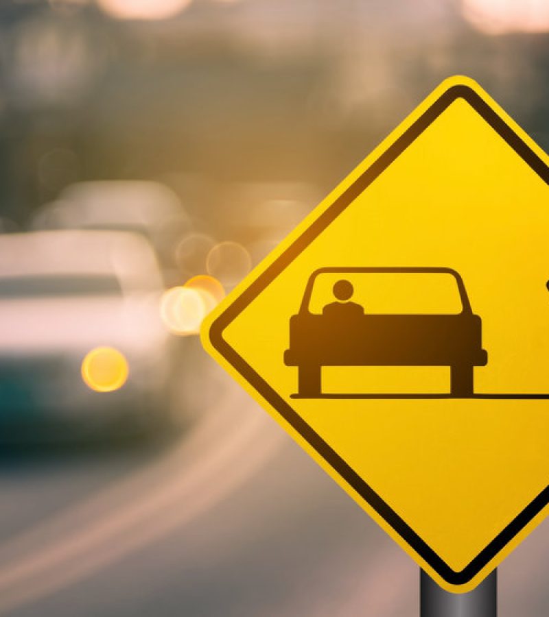 Bicycle and car share warning sign on blur traffic road with colorful bokeh light abstract background. Copy space of transportation and travel concept. Vintage tone filter effect color style.